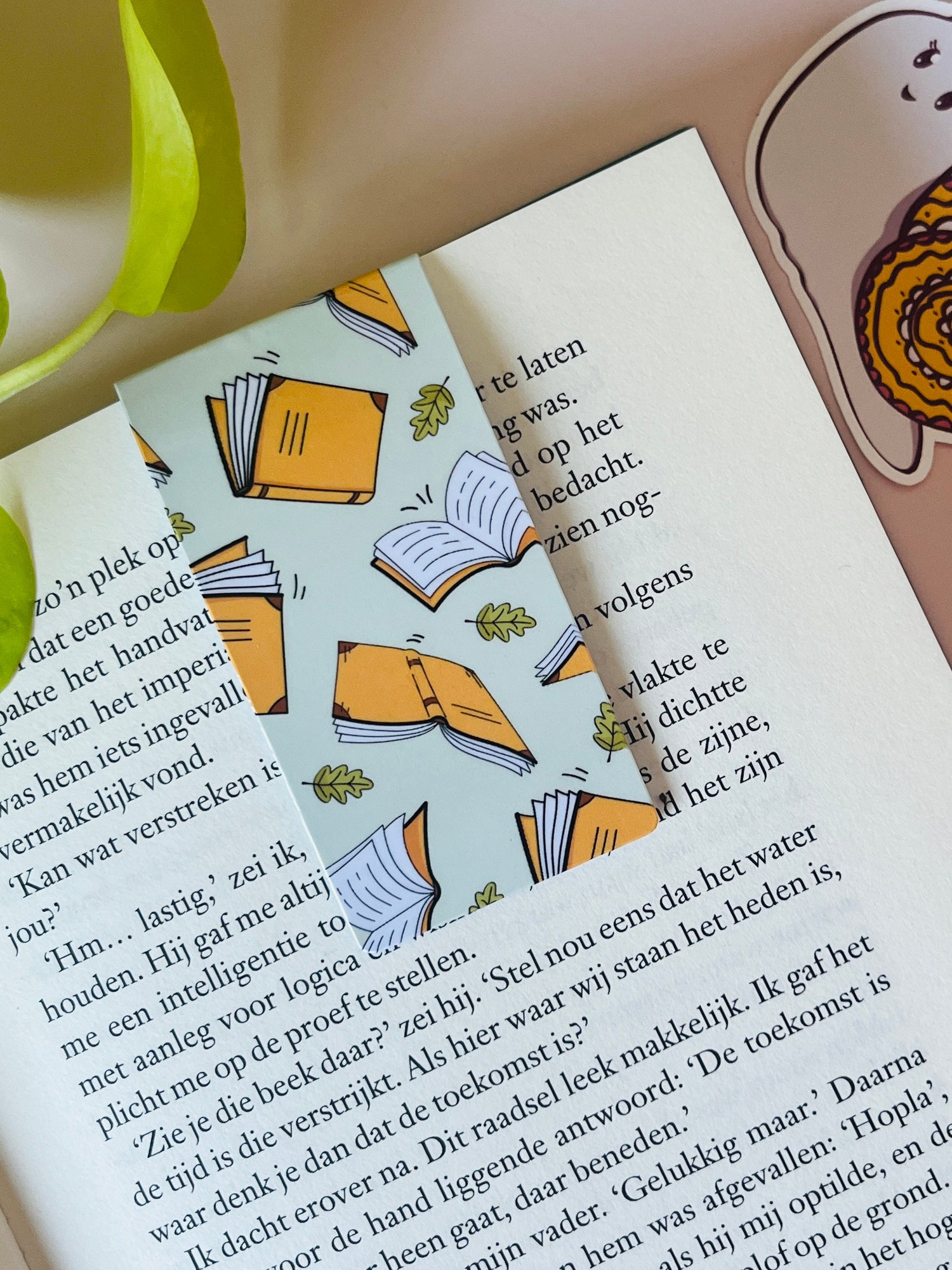 Magnetiche boekenlegger voor boekenliefhebbers, pastelgroen met illiustatie van vallende boeken en kleine groene herfstblaadjes