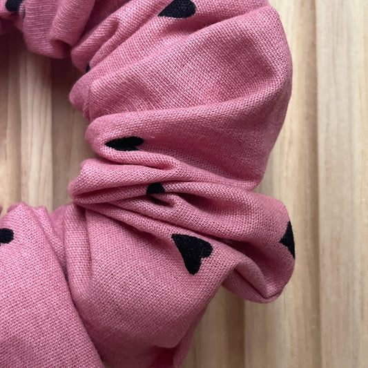 Haar scrunchie van oud roze poplin katoen met kleine zwarte hartjes. Elastisch en geschikt om een staart of knot vast te maken. Handgemaakt door Studio Dwarsdenker