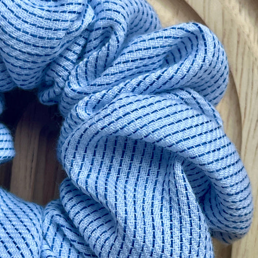 Haar scrunchie van zacht katoen, wit met blauw strepen patroon. Elastisch en geschikt om een staart of knot vast te maken. Handgemaakt door Studio Dwarsdenker