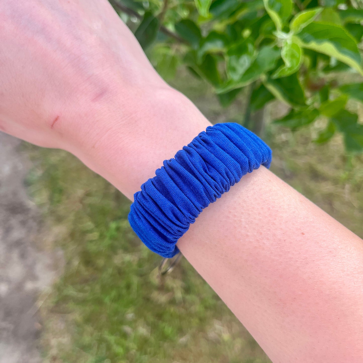 Sleutelhanger in de vorm van een Scrunchie voor om je pols. Van stof met elastiek in cobalt blauw. Met bronskleurige klem/ring. Handgemaakt door Studio Dwarsdenker.