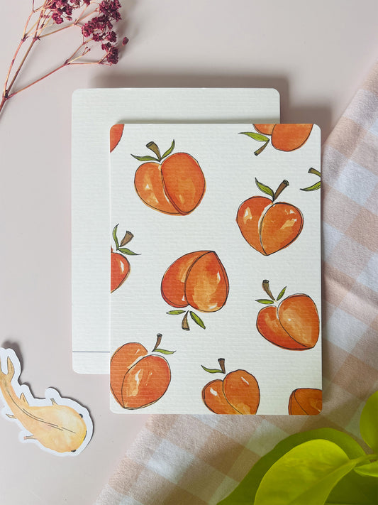 Ansichtkaart met een waterverf illustrstie van perziken in oranje tinten en een witte achtergrond. Ontwerp door Studio Dwarsdenker