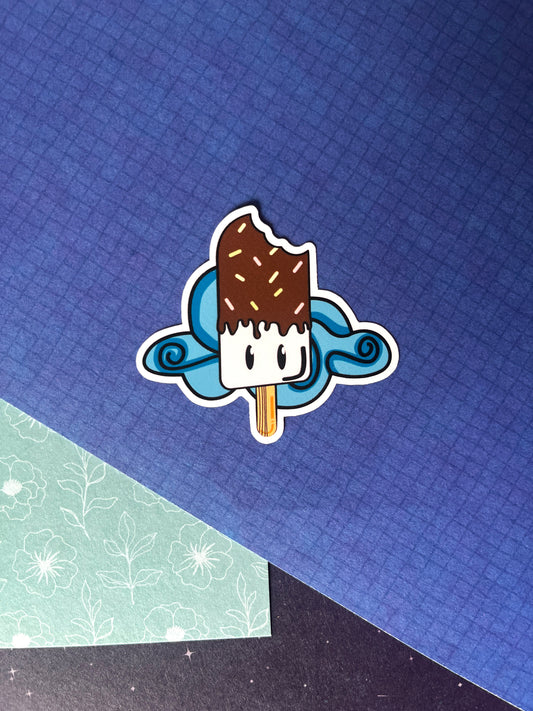 Sticker in zomers thema. Bestaande uit een chocolade ijsje met lachend gezichtje en een wolkje op de achtergrond. kleuren; blauw, geel, roze, bruin. Ontwerp door Studio Dwarsdenker
