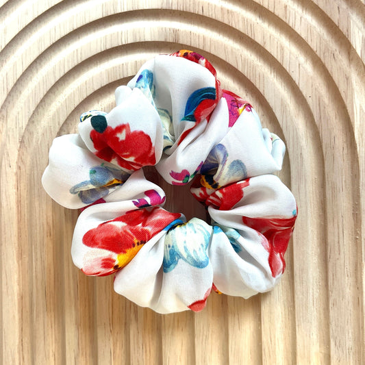 Haar scrunchie van satijn katoen in wit met bloemenpatroon. Elastisch en geschikt om een staart of knot vast te maken. Handgemaakt door Studio Dwarsdenker