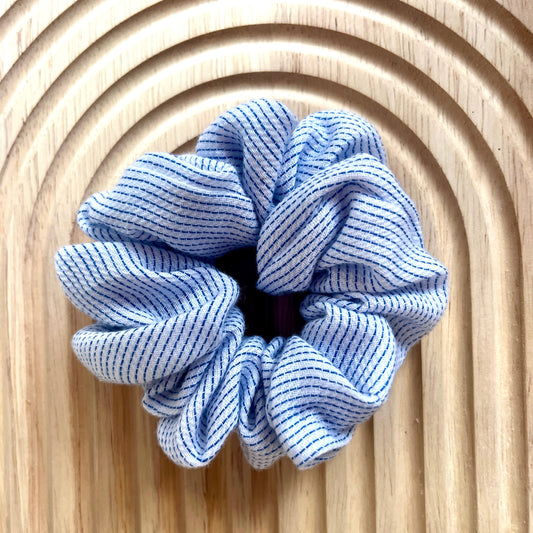 Haar scrunchie van zacht katoen, wit met blauw strepen patroon. Elastisch en geschikt om een staart of knot vast te maken. Handgemaakt door Studio Dwarsdenker
